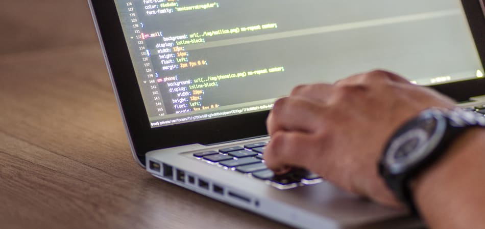 Laptop met iemand die codes intypt