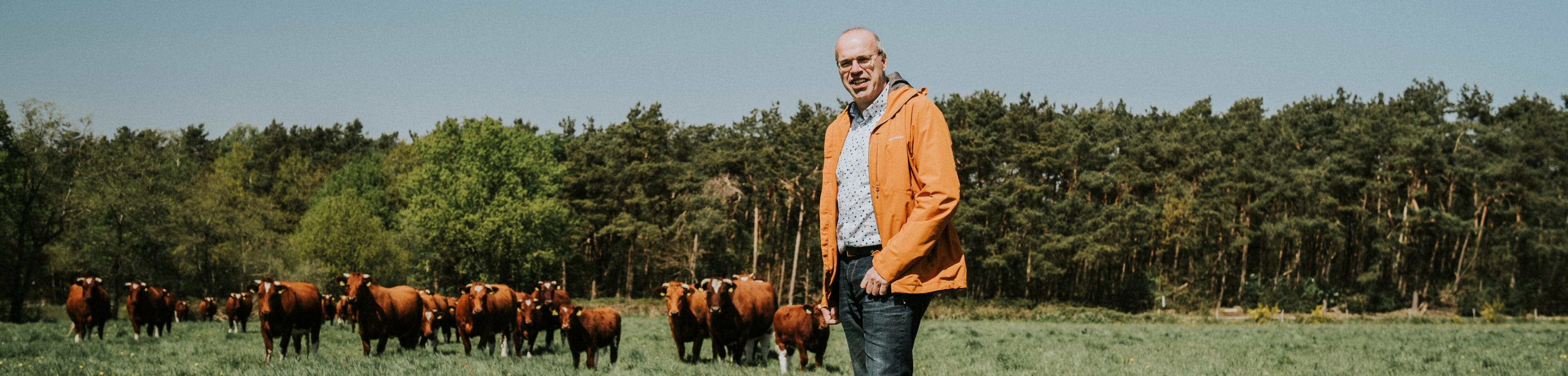 Eigenaar Johan Martens staat voor zijn koeien op het terrein van zorgboerderij Hemelrijksche Hoeve.