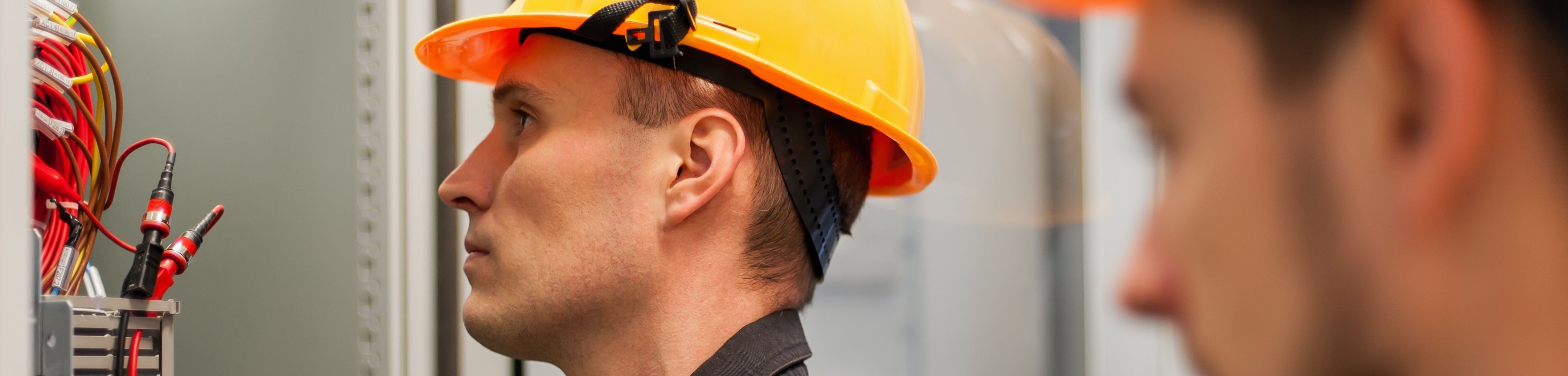 Man met bouwhelm op werkt aan de meterkast