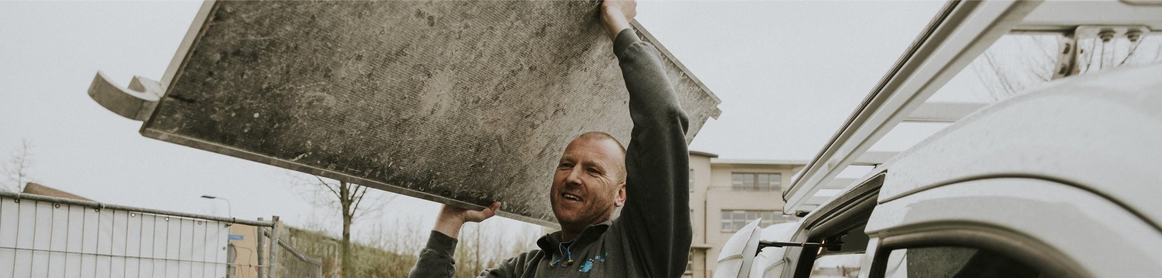 ondernemer in de bouw die een steigerplaat tilt