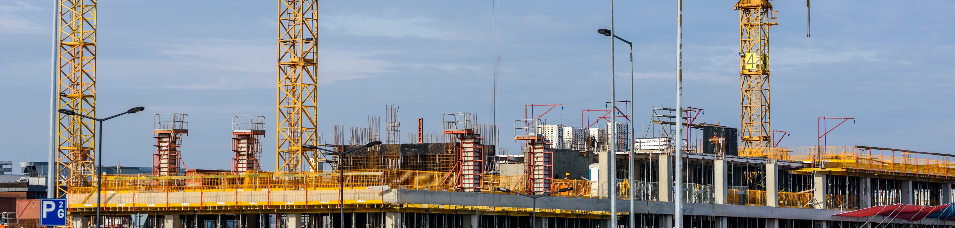 Een bouwplaats met 3 hijskranen
