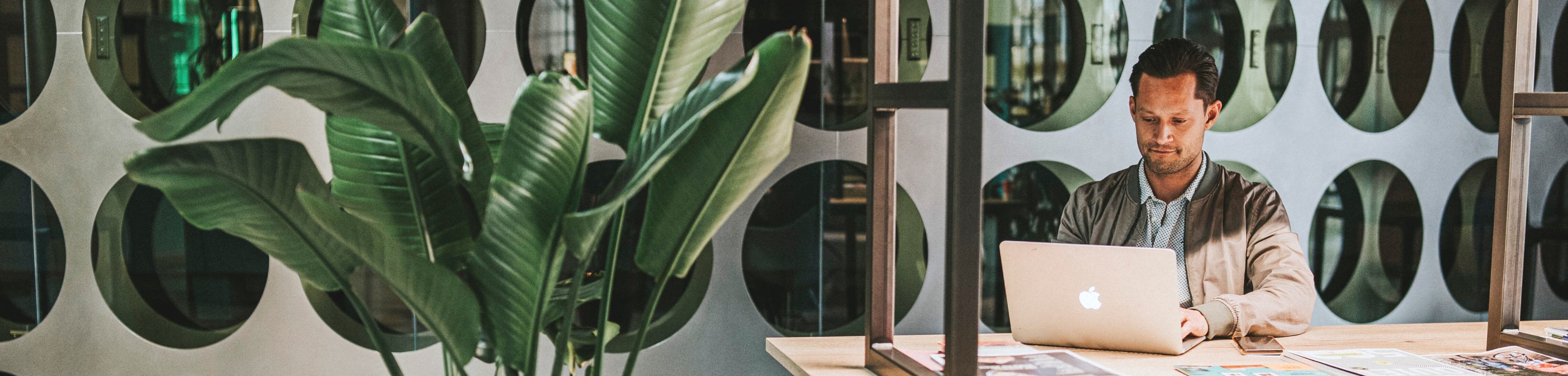 Man zit achter laptop en denkt na