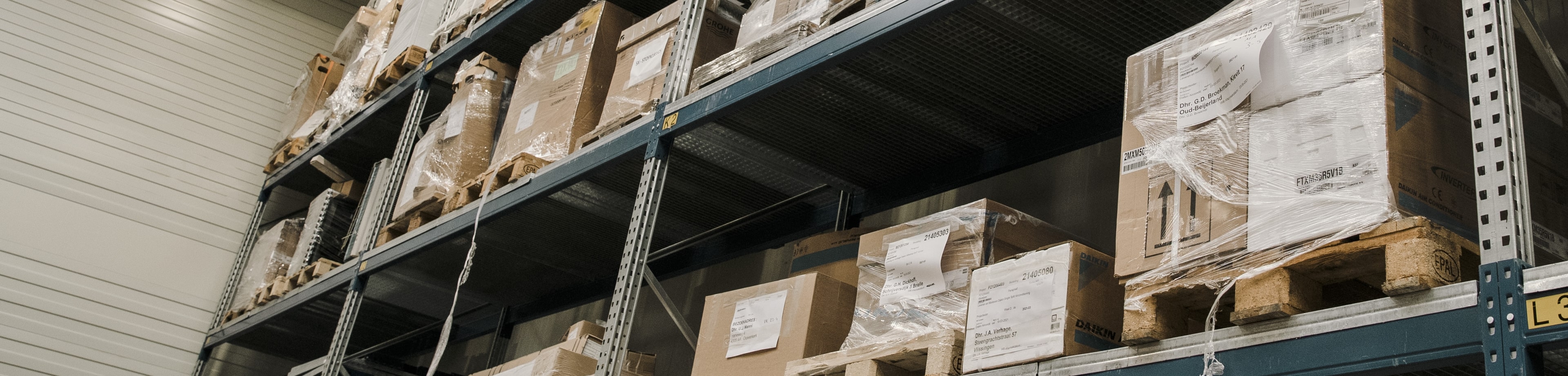 Magazijnstellingen in een bedrijfshal met daarop pallets.