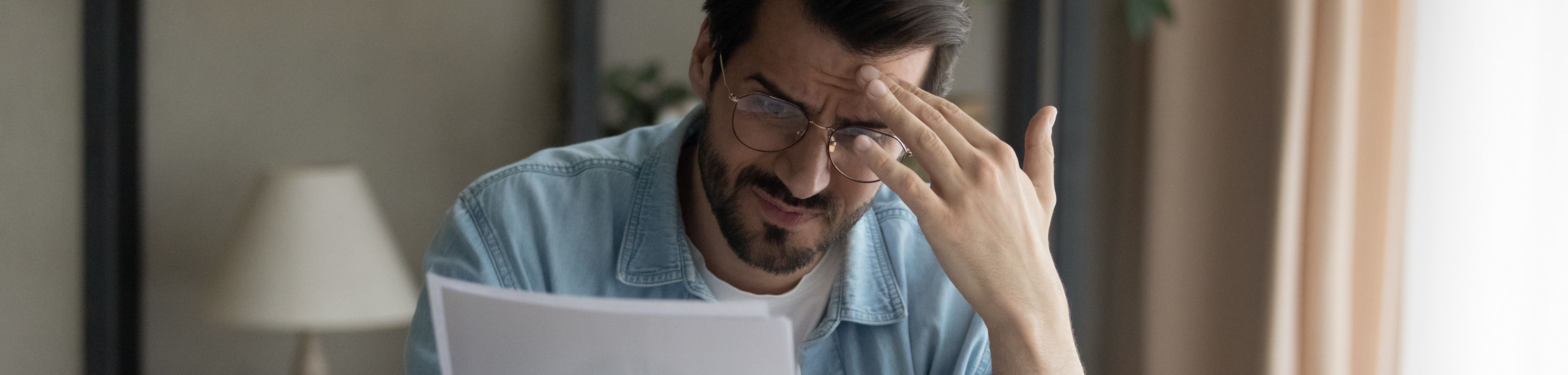 Man achter laptop leest iets wat hem bezorgd maakt