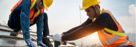 2 mannen met helm op aan het werk in de bouw