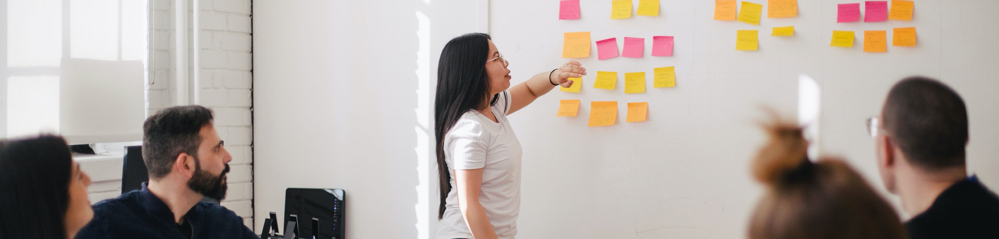 Een vrouw voor een whiteboard met post-its