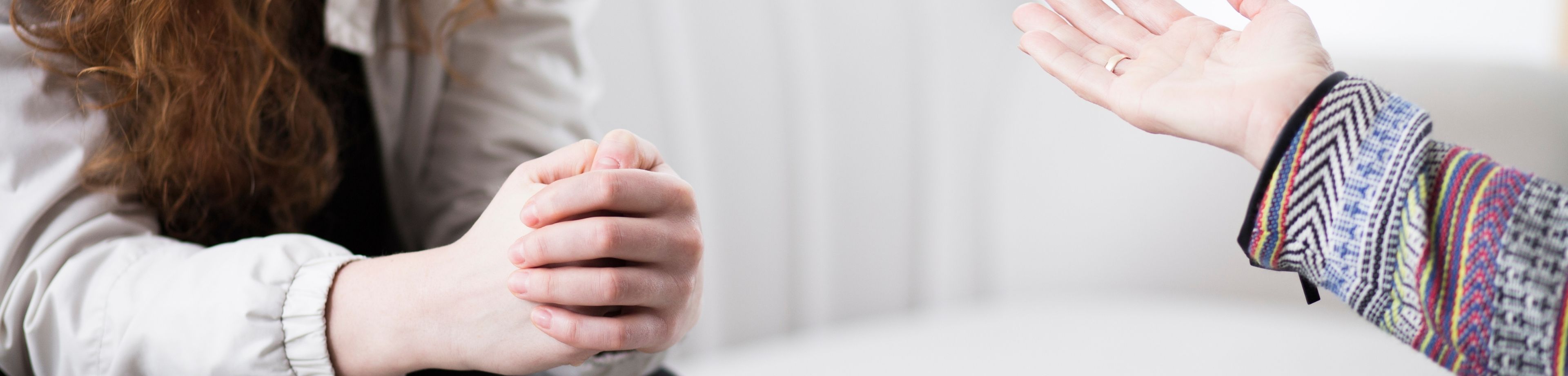 Handen van 2 mensen die met elkaar in gesprek zijn