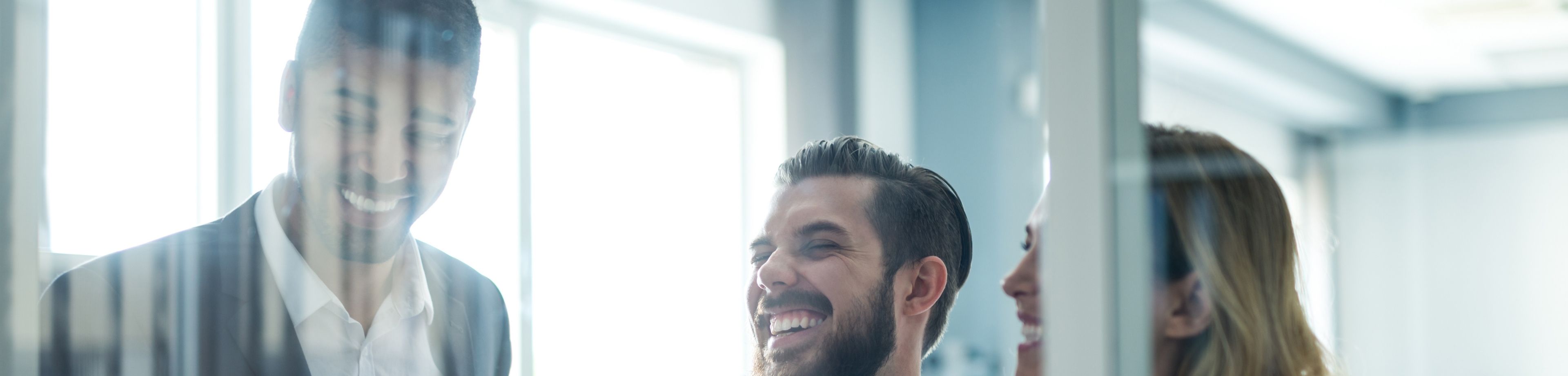 2 mannen en 1 vrouw overleggen met elkaar, in een kantooromgeving