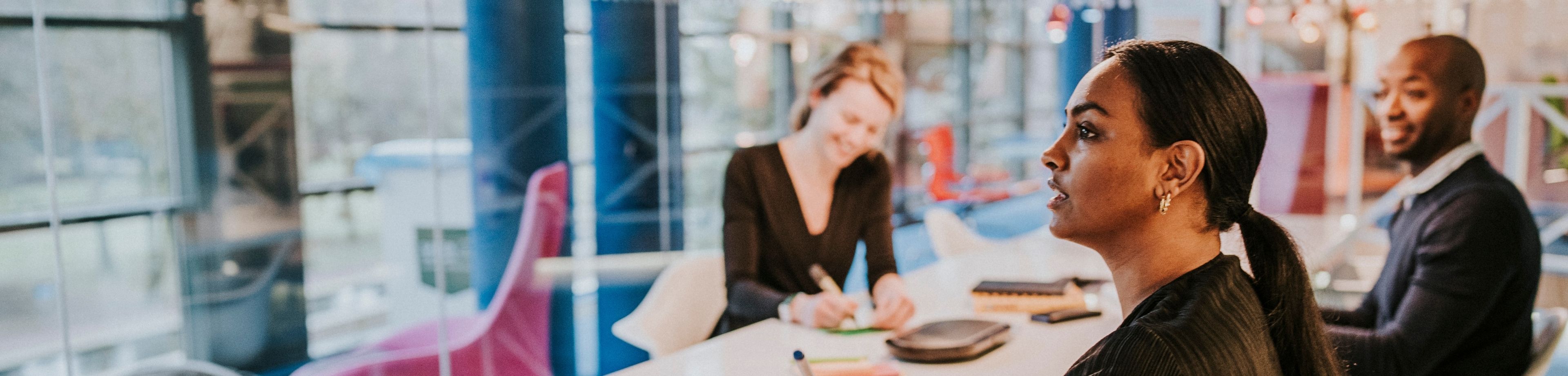 Collega's op kantoor praten met elkaar. Ziekteverzuim is dit jaar met 50% gestegen. 