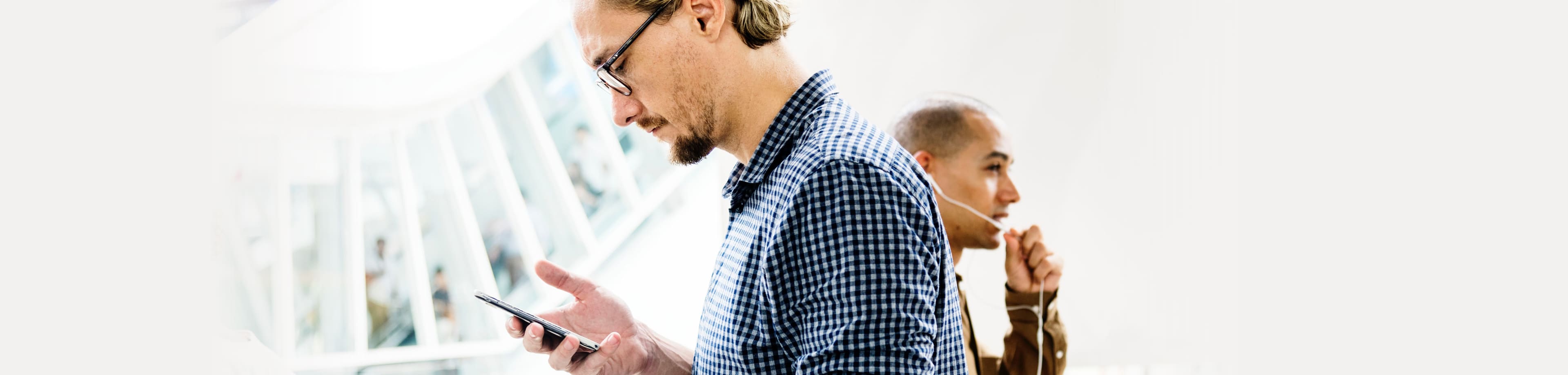 Man kijkt naar de mobiele telefoon in zijn hand