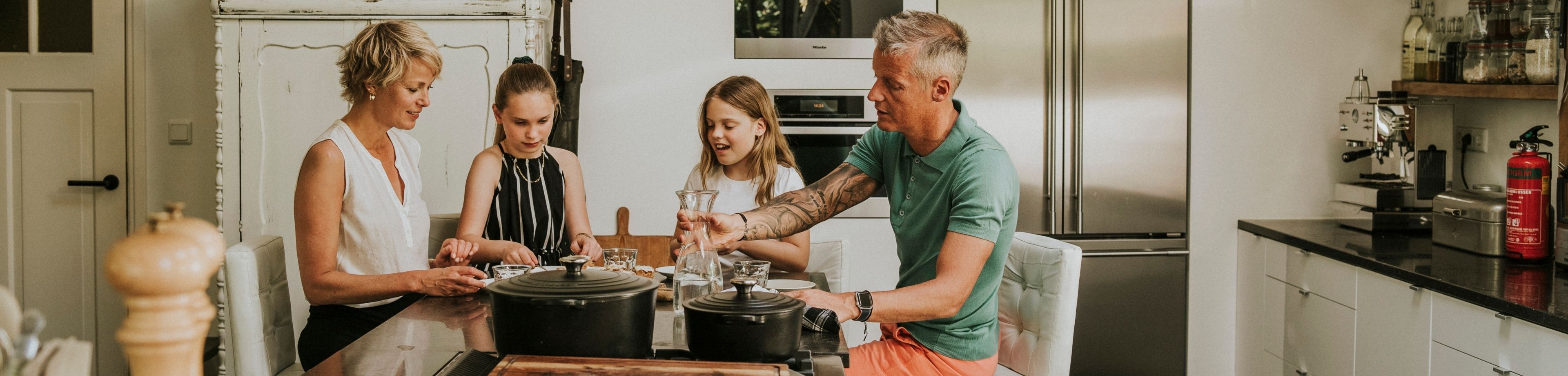 Gezin met 2 kinderen eet aan de keukentafel