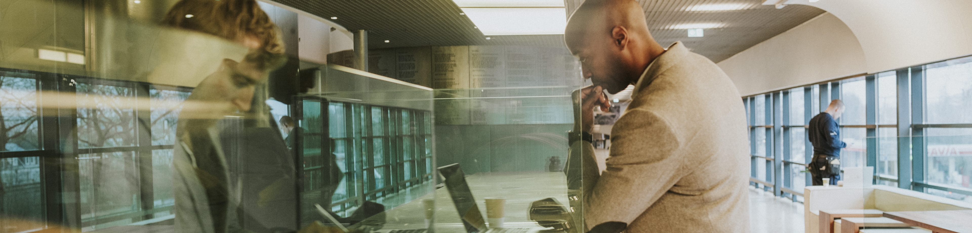 Een man denkt na achter een laptop