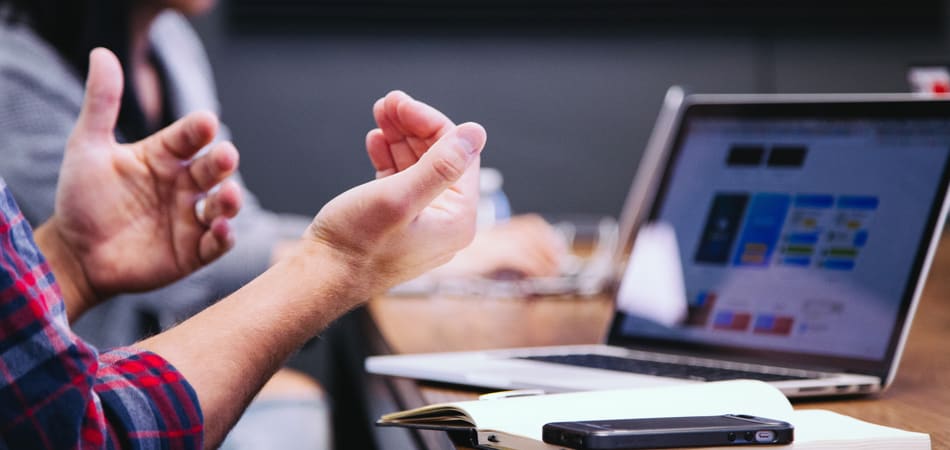 Iemand die achter zijn laptop aan het werk is
