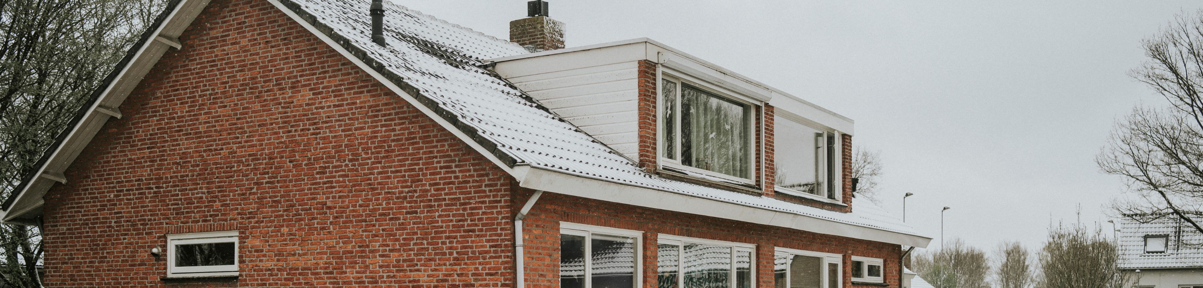 Een rij huizen met sneeuw op het dak