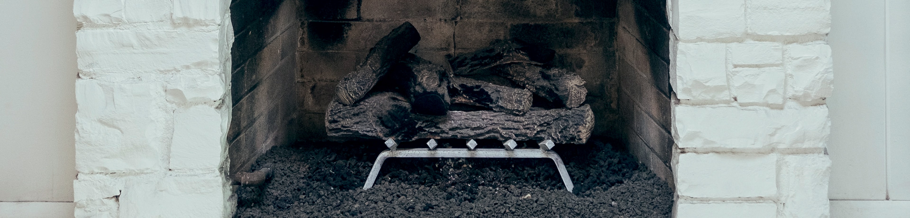 Een open haard met verbrande houtblokken erin