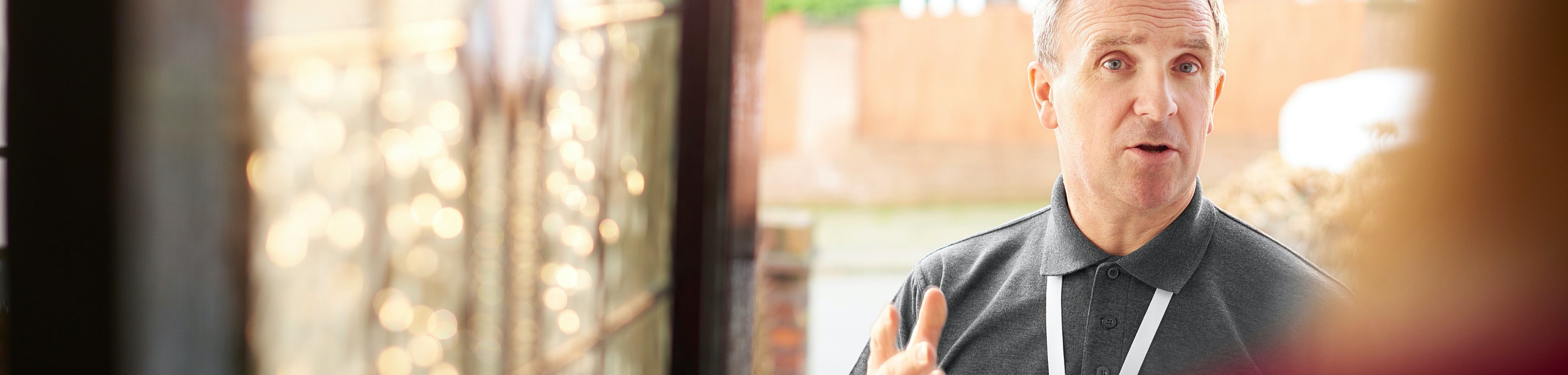 Man met keycord die aan de deur staat en aan het praten is