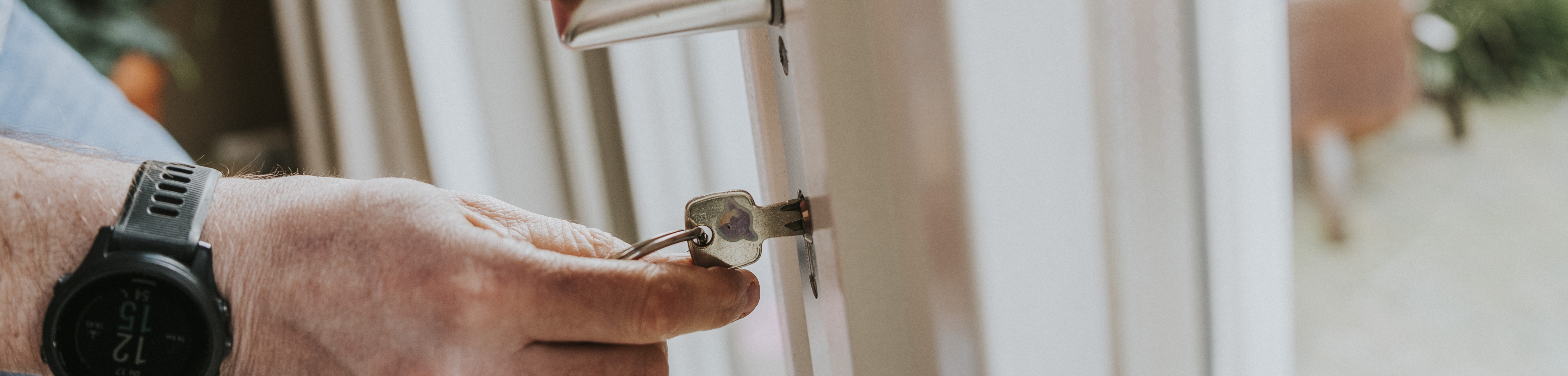 Iemand steekt de sleutel in een slot