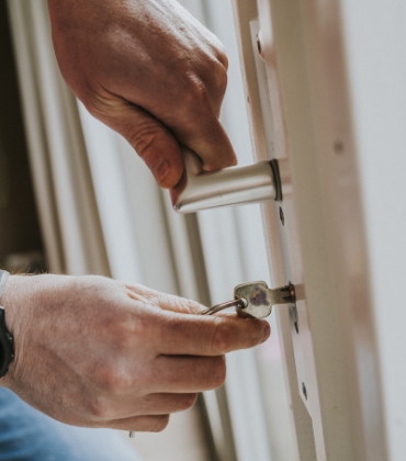 Iemand steekt de sleutel in een slot