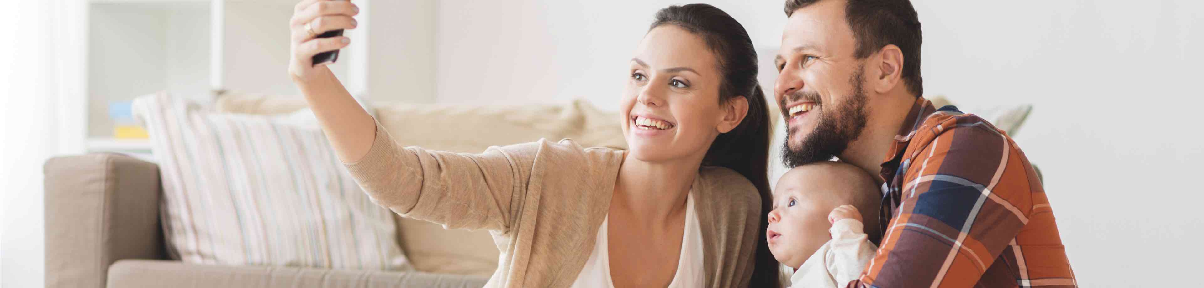 Man en vrouw met hun baby die met een smartphone een foto maken