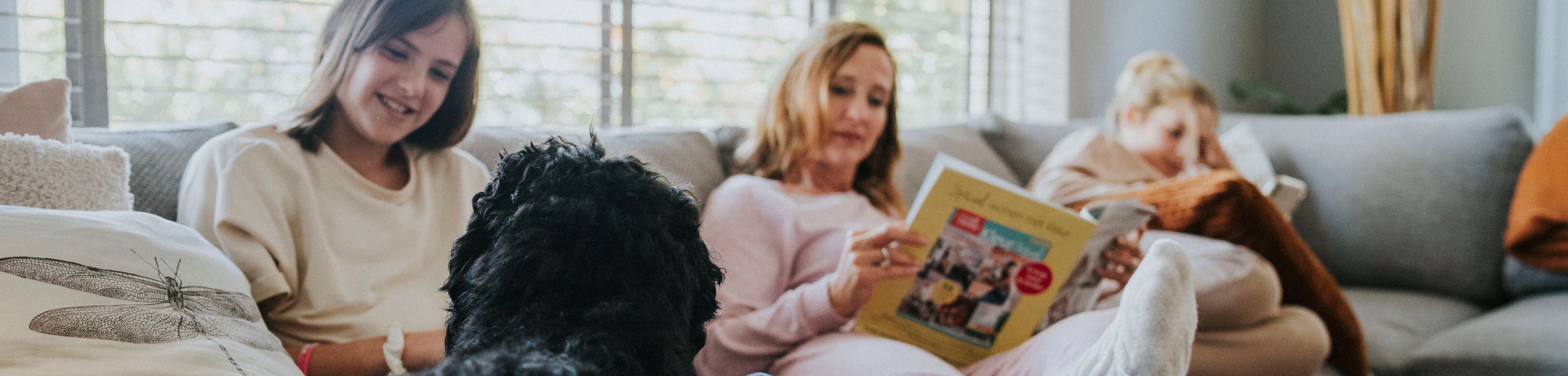Gezin zit gezellig samen op de bank, met de hond