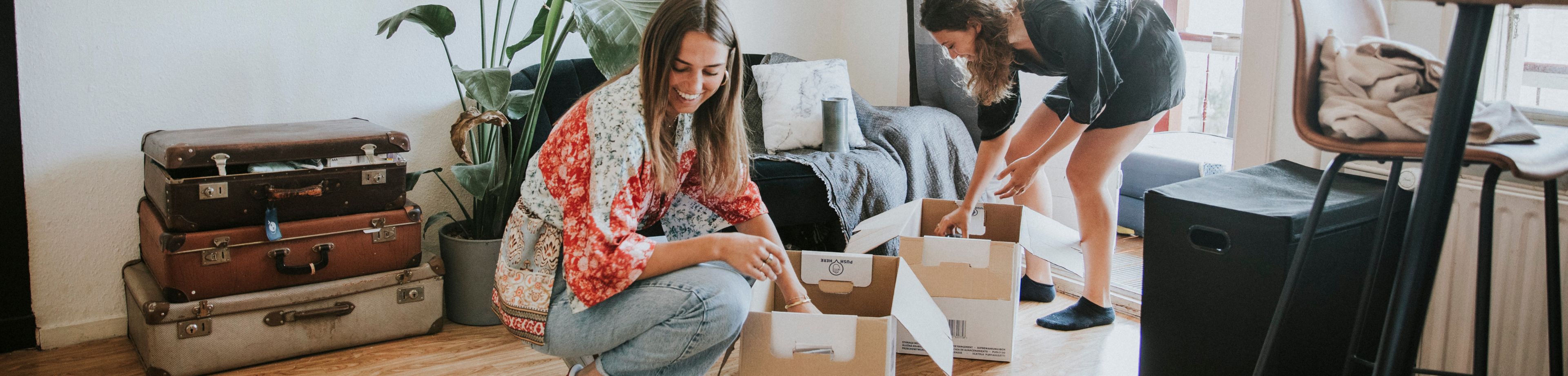 2 meiden pakken verhuisdozen in