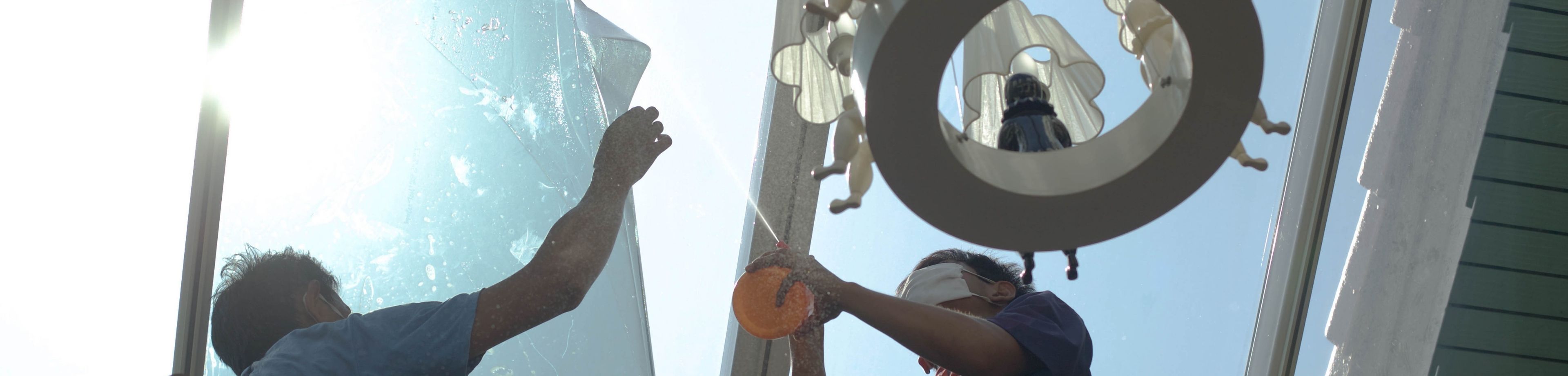 2 mannen plaatsen inbraakwerende raamfolie op een raam