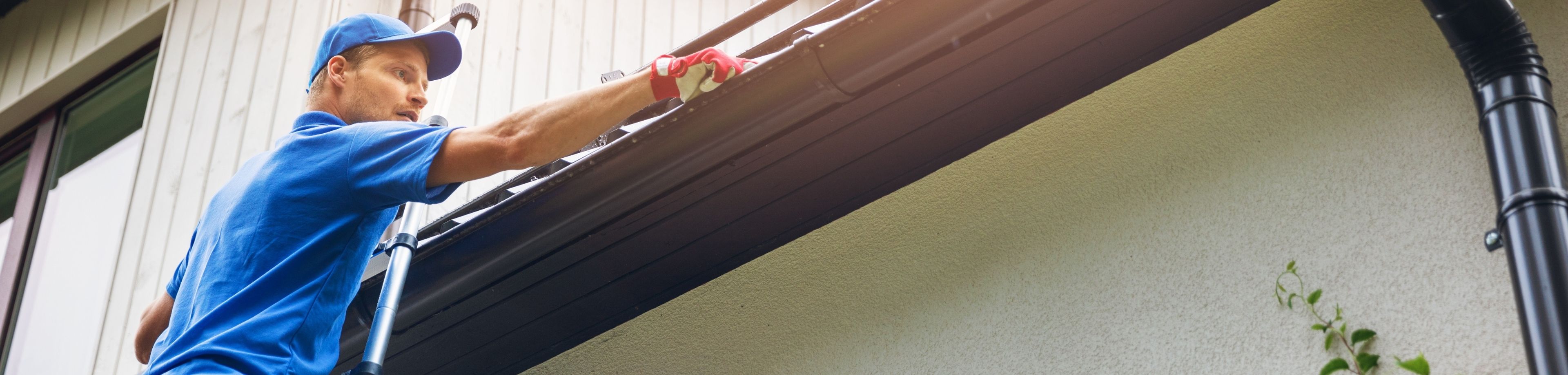 Loodgieter aan het werk bij een dakgoot