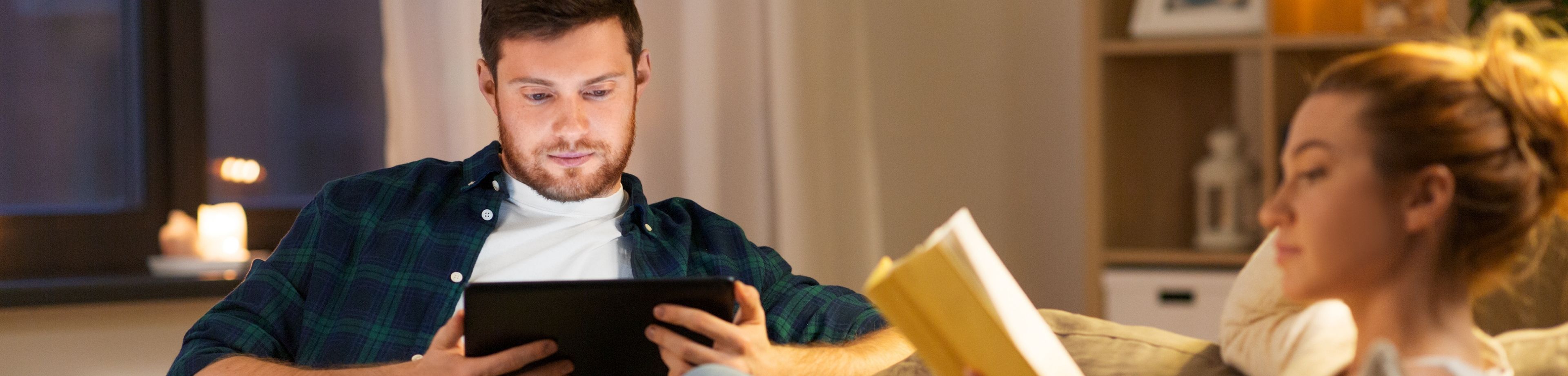 Man en een vrouw die op de bank aan het lezen zijn