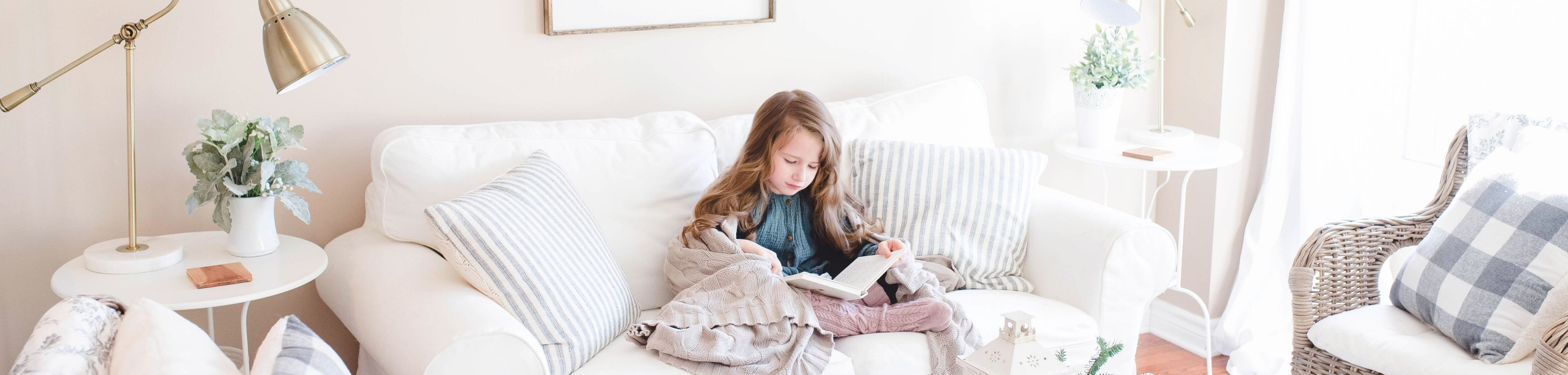 Meisje dat op de bank ligt te lezen