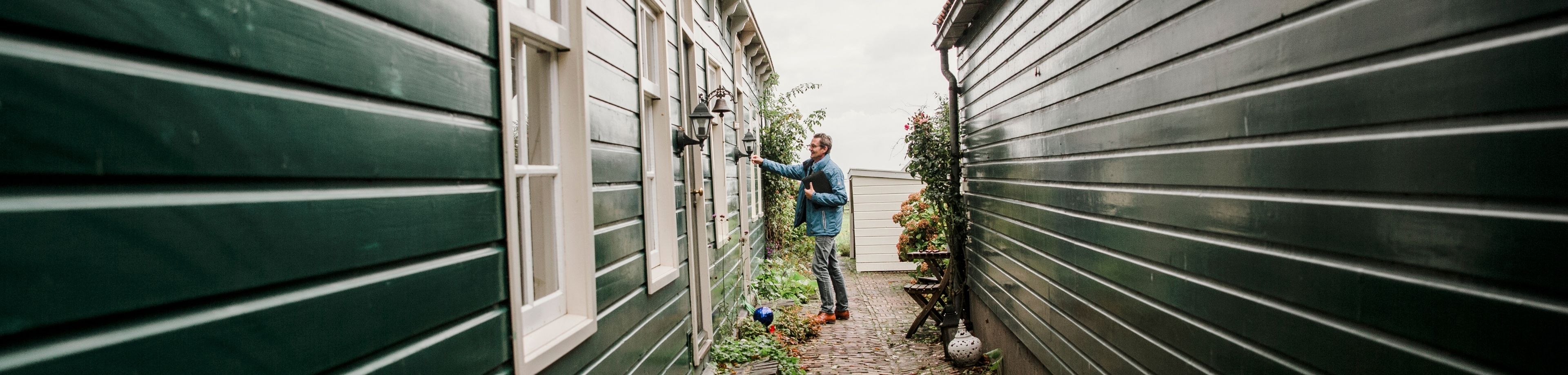Man belt aan bij houten huis. Tips om jouw huis brandveilig te maken.