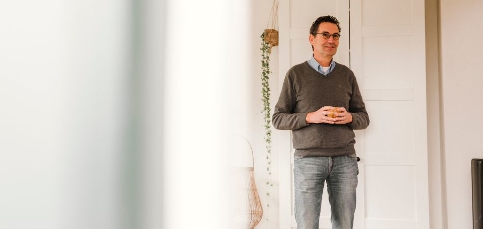 Man staat in woonkamer.