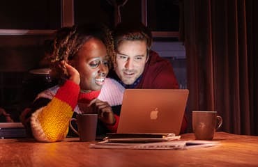 Man en vrouw kijken naar laptop.