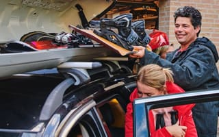 Man legt snowboard in box op de auto.
