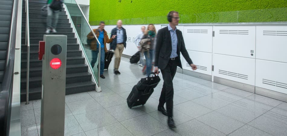 Man loopt in pak met koffer op vliegveld.