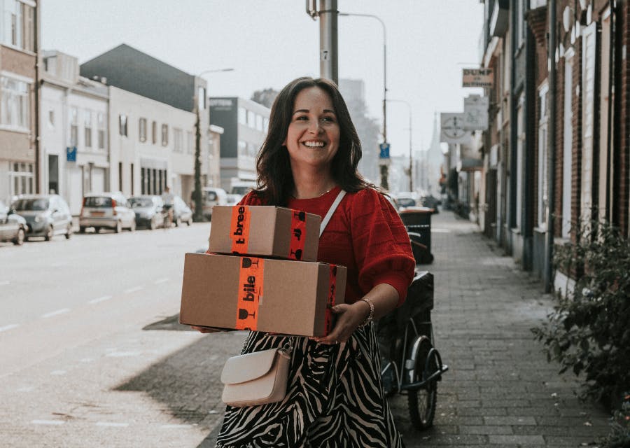 Vrouw loopt met dozen door haar straat | Eigen bedrijf starten | Interpolis
