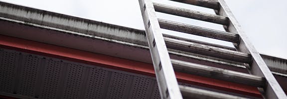 Een ladder die tegen het dak van een woning aanstaat. Door je tuin op te ruimen en opklimmen te voorkomen, verklein je de kans dat inbrekers binnenkomen.
