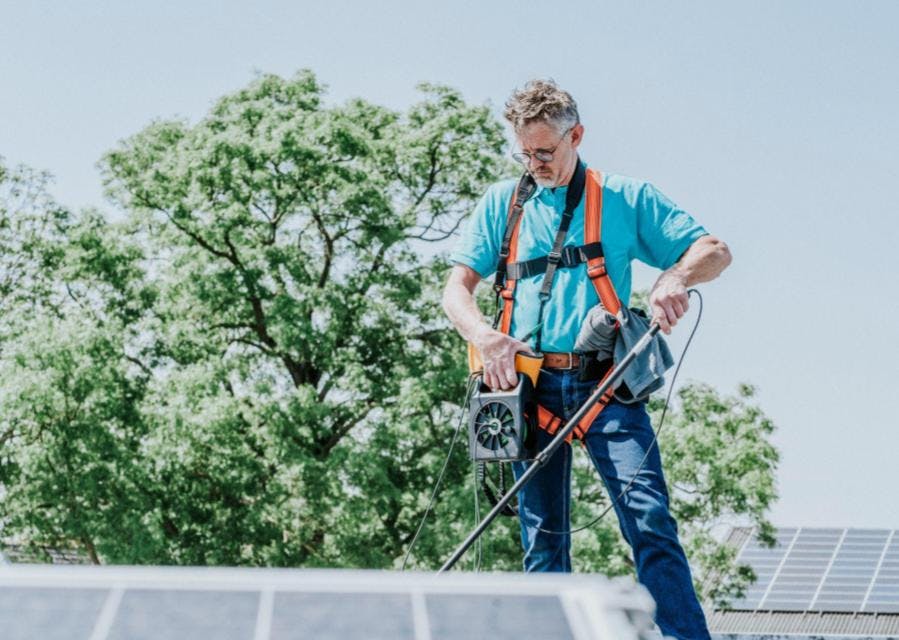 Man in Interpolis t-shirt voert een elektrakeuring uit op zonnepanelen